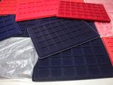 a pile of red, blue, and black plastic trays on a table