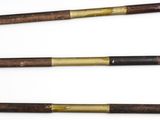 three old wooden and brass baseball bats on a white surface