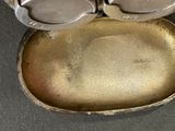 a small metal container with two lids on a table