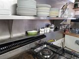 many plates and bowls on the shelves in the kitchen