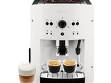 a white coffee machine with two cups of coffee next to it