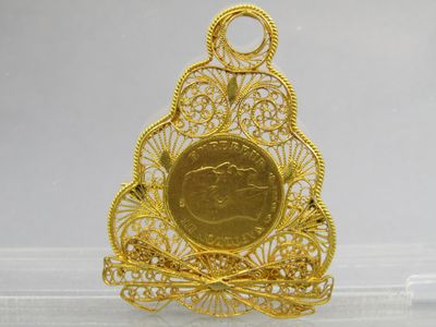 an image of a gold coin in a filigree filigree pendant