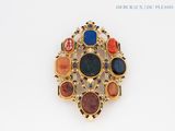 a gold brooch with multi colored stones on it