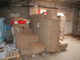 boxes stacked on pallets in a room with a lot of other boxes
