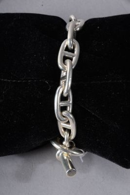 silver plated chain bracelet with a charm on a black velvet bow tie