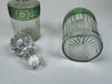 two glass bottles and a glass stopper on a table