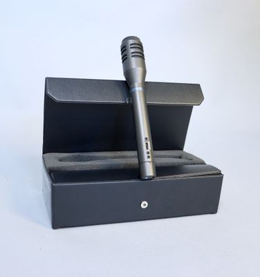 a microphone in a black box on a white surface