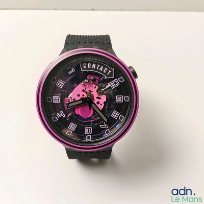 une montre noire et rose posée sur une surface blanche