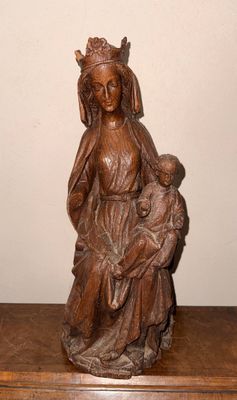statue en bois représentant une femme tenant un enfant dans ses bras, posée sur une table