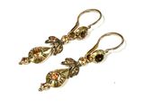 pair of gold tone earrings with garnets on them