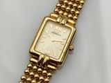 a close up of a gold watch on a white surface