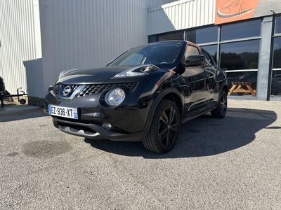 La Nissan Juke noire est garée devant un immeuble.