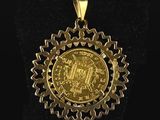 a gold coin pendant with a crown on it