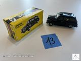 une petite voiture miniature posée à côté d'une boîte d'allumettes