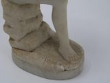 a statue of a woman sitting on a rock