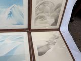 four framed photographs of a mountain range are displayed on a table