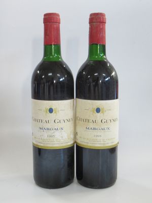 two bottles of red wine sitting next to each other on a table