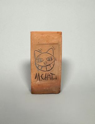 a wooden block with a drawing of a cat on it