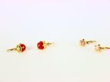 un lot de trois paires de boucles d'oreilles ornées de pierres rouges et roses
