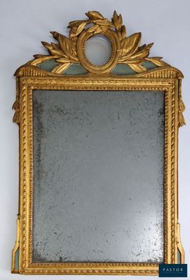 an image of a gold framed mirror hanging on a wall