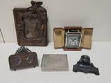 une table sur laquelle se trouvent une horloge, un cadre photo et d'autres objets