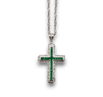 un gros plan d'un pendentif en forme de croix muni d'une chaîne, sur fond blanc