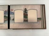an open book with a picture of a lake and mountains in the background