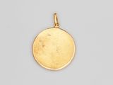 un pendentif plaqué or présentant un motif rond sur fond blanc