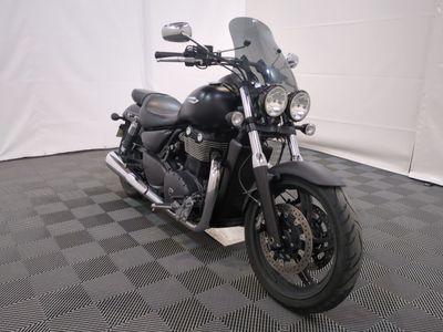 une moto noire garée sur un sol à damier
