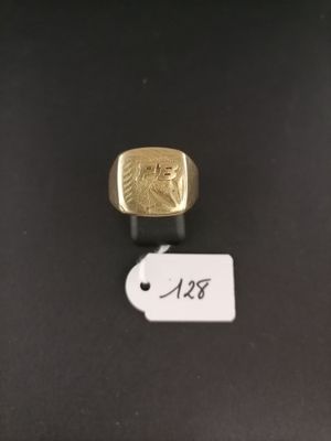 a close up of a gold ring on a black surface with a price tag