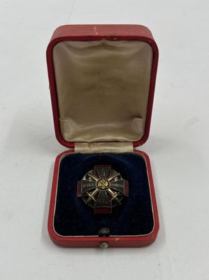 une petite boîte rouge contenant une médaille en argent et en or