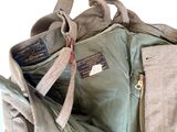 un sac posé par terre, muni d'une fermeture éclair