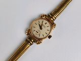 une image d'une montre-bracelet en or avec des chiffres romains