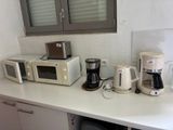 Il y a de nombreux types d'appareils électroménagers posés sur le plan de travail de cette cuisine