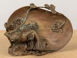 a bronze sculpture of a woman with flowers on her head