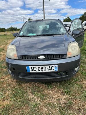 La voiture est garée sur l'herbe, dans le champ.