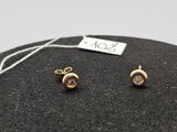 un gros plan sur une paire de boucles d'oreilles posées sur un rocher