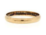 gros plan d'une bague en or sur fond blanc