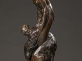 a bronze statue of a man holding a child on a rock