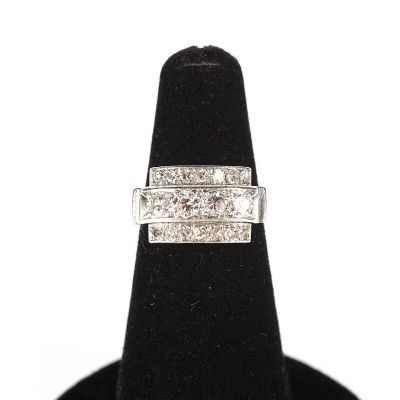 un gros plan d'une bague en diamant posée sur un présentoir noir