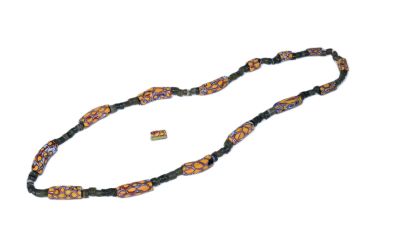 collier à perles noires et orange avec un fermoir doré, sur fond blanc