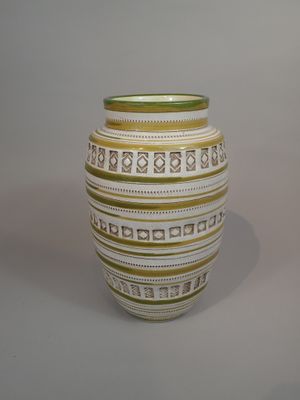 un vase blanc et vert posé sur une table