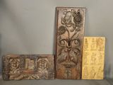 three pieces of wood with carvings on them sitting on a table