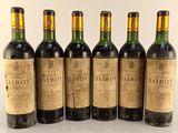 six bottles of wine are lined up on a white surface