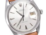 a close up of a watch with a white dial and brown leather strap