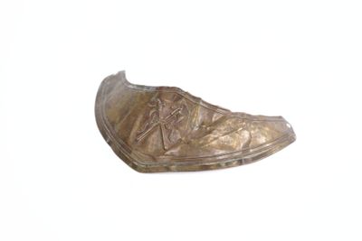 une chaussure en bronze posée sur une surface blanche