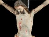 a statue of jesus on a cross with blood all over it