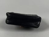 the small black purse is sitting on a white surface