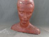 une sculpture en argile représentant la tête d'une femme, posée sur une table