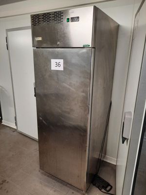 a metallic refrigerator in the middle of a room